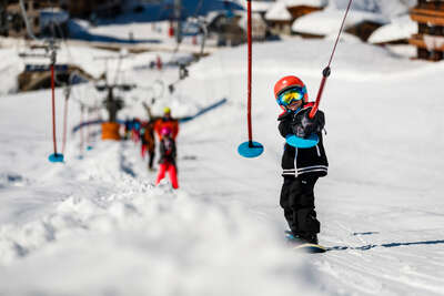Kind, das mit dem Snowboarden anfängt in Tignes
